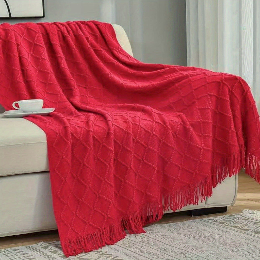 Plaid tricot losange à franges rouge sur un canapé