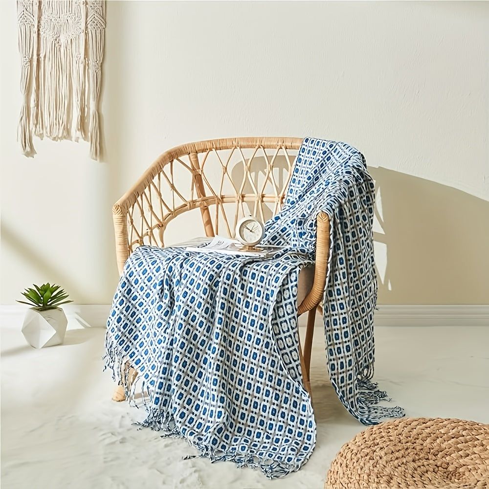 Plaid jacquard à franges bleu sur un fauteuil en rotin Image