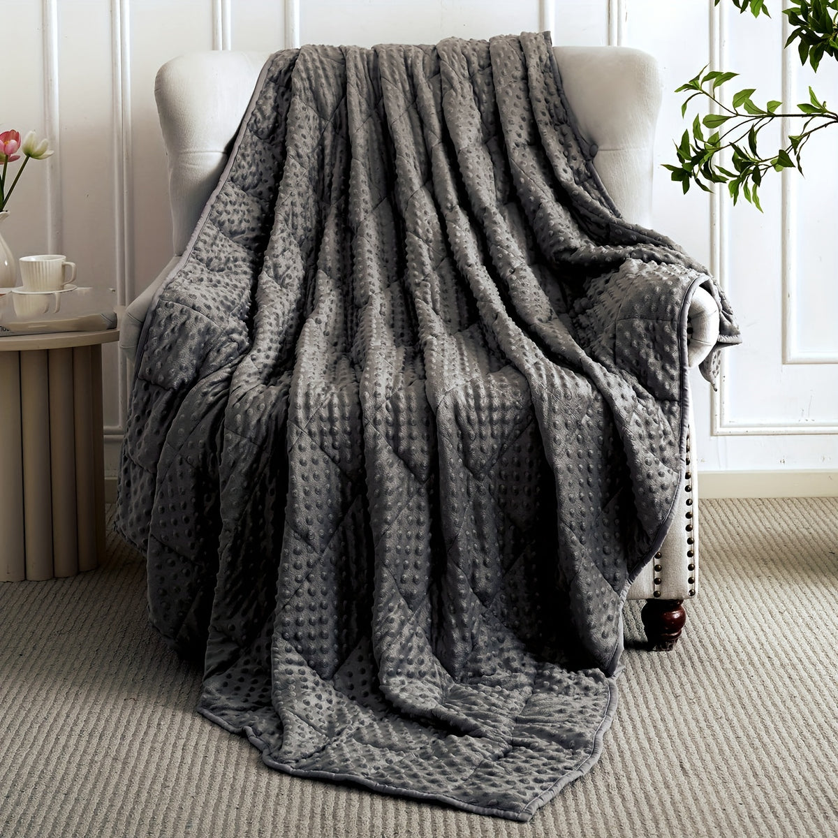 Couverture lestée grise texture gaufrée – posée sur fauteuil
