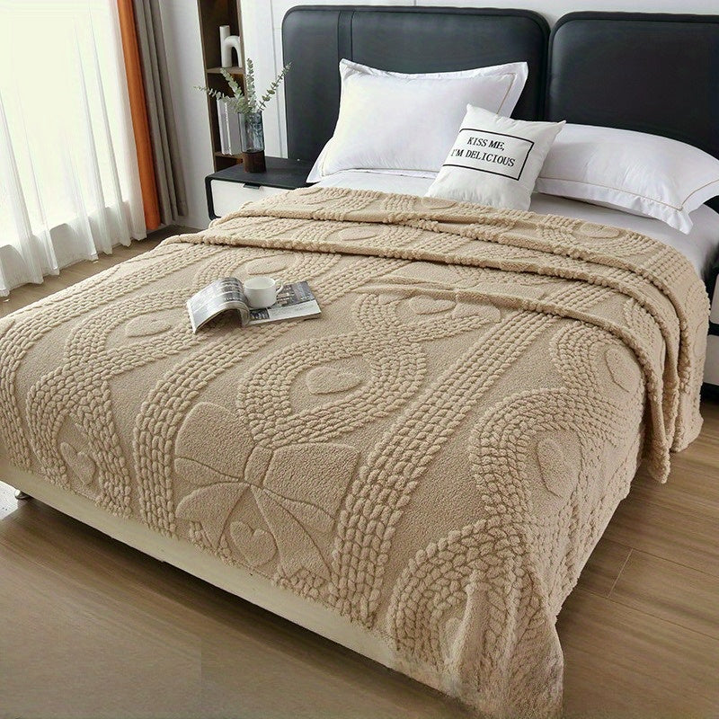 Plaid jacquard torsadé beige sur un lit
