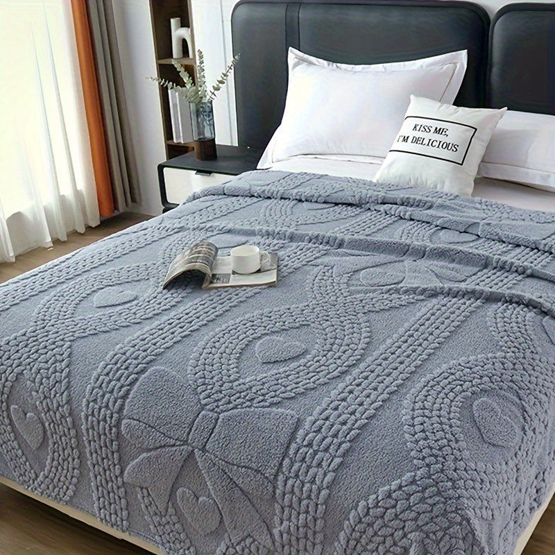 Plaid jacquard torsadé gris bleu sur un lit Image