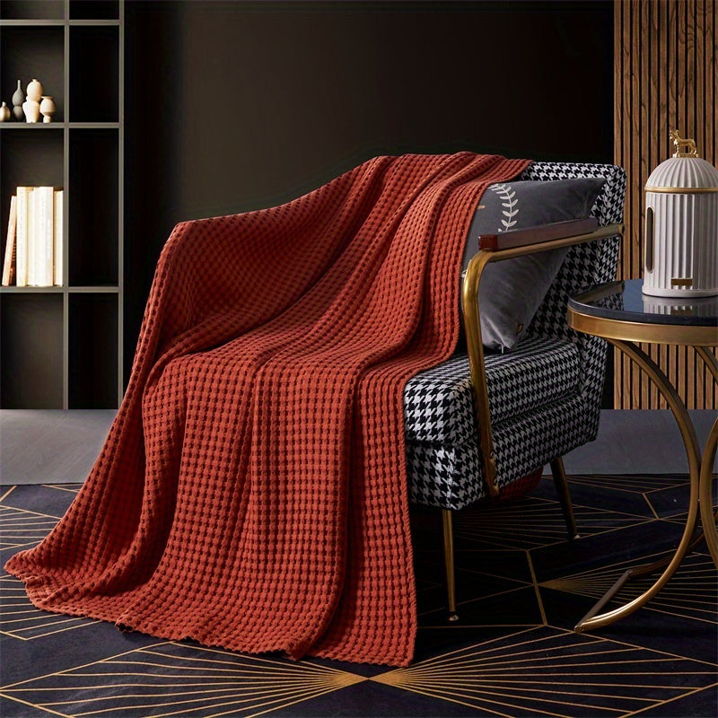 Plaid nid d'abeille en coton terracotta sur un fauteuil
