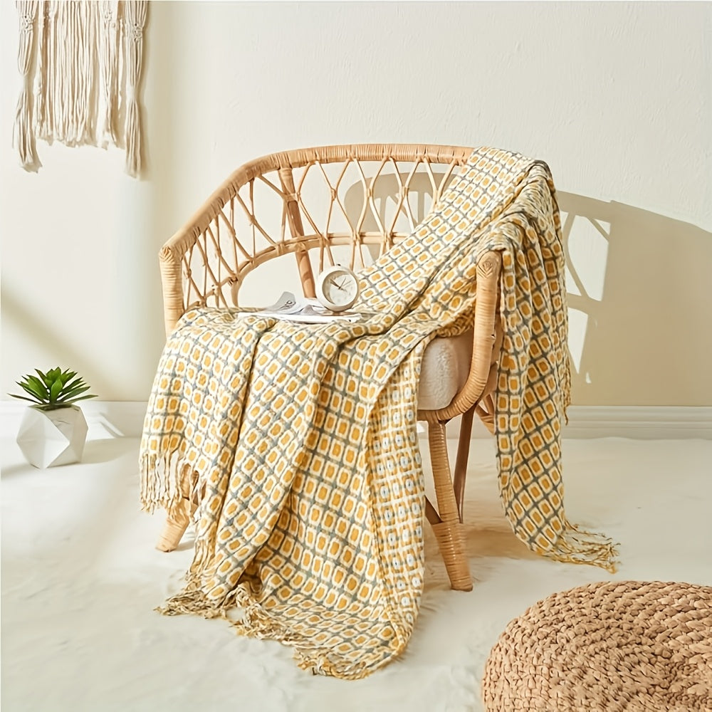Plaid jacquard à franges jaune sur un fauteuil en rotin