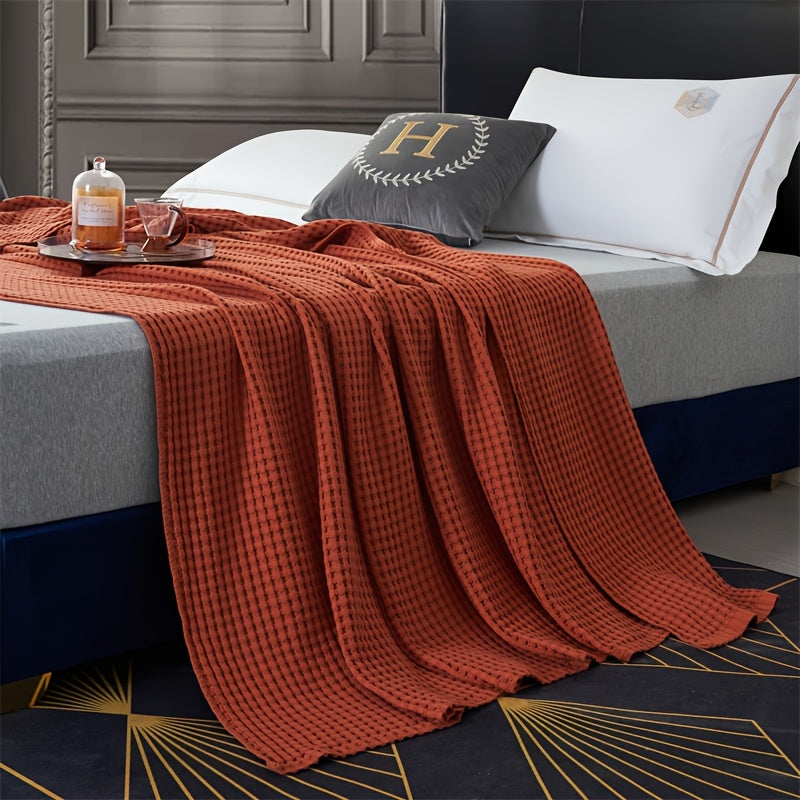 Plaid nid d'abeille en coton terracotta sur un lit
