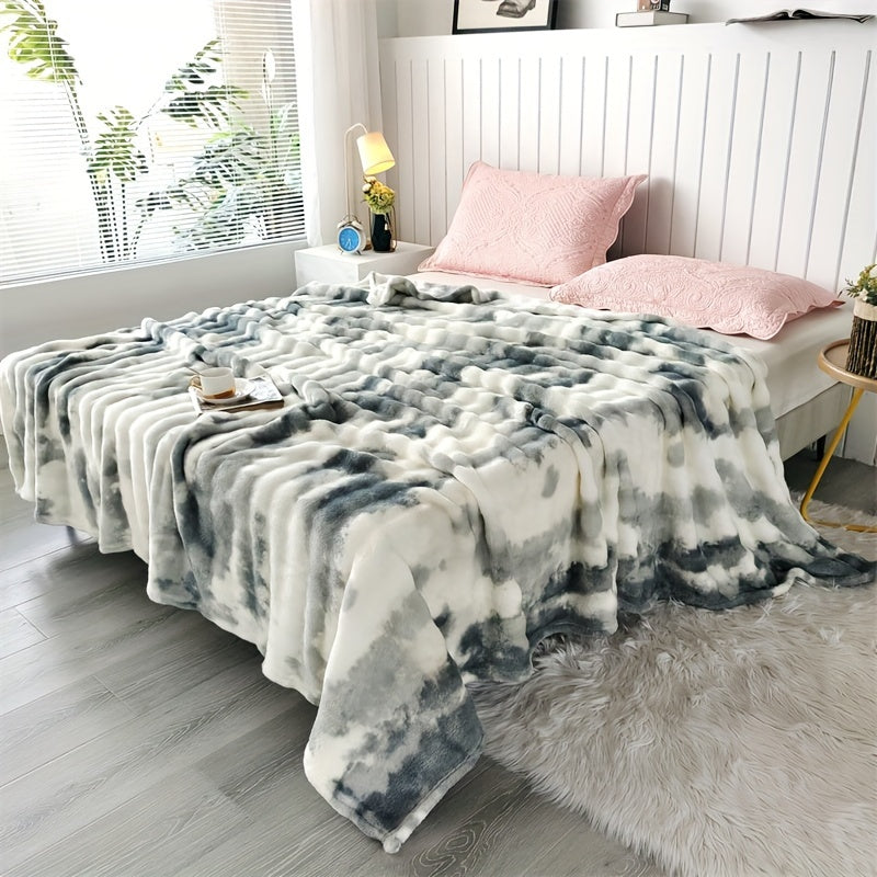 Plaid peluche imprimé tie-dye encre grise sur un lit