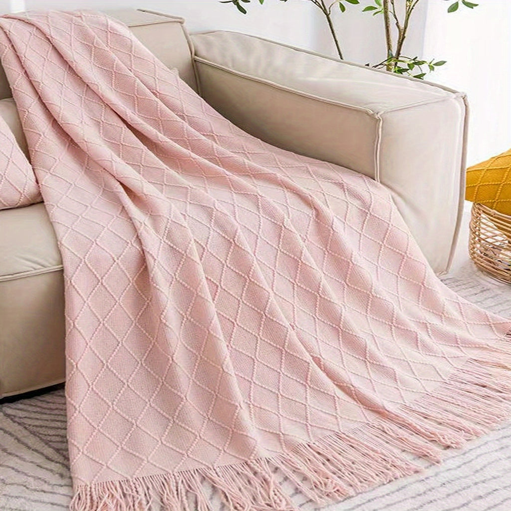 Plaid tricot losange à franges rose sur un canapé